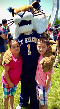 Ella and Satchel Ortez hang out with Rufus Bobcat during an event on campus.